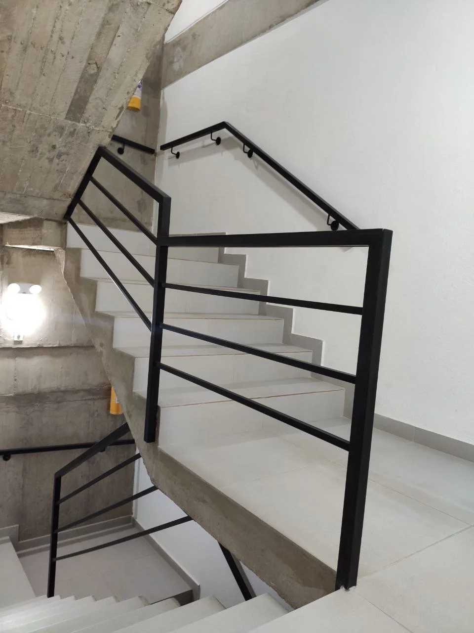 Pasamanos metálico negro en escalera de concreto