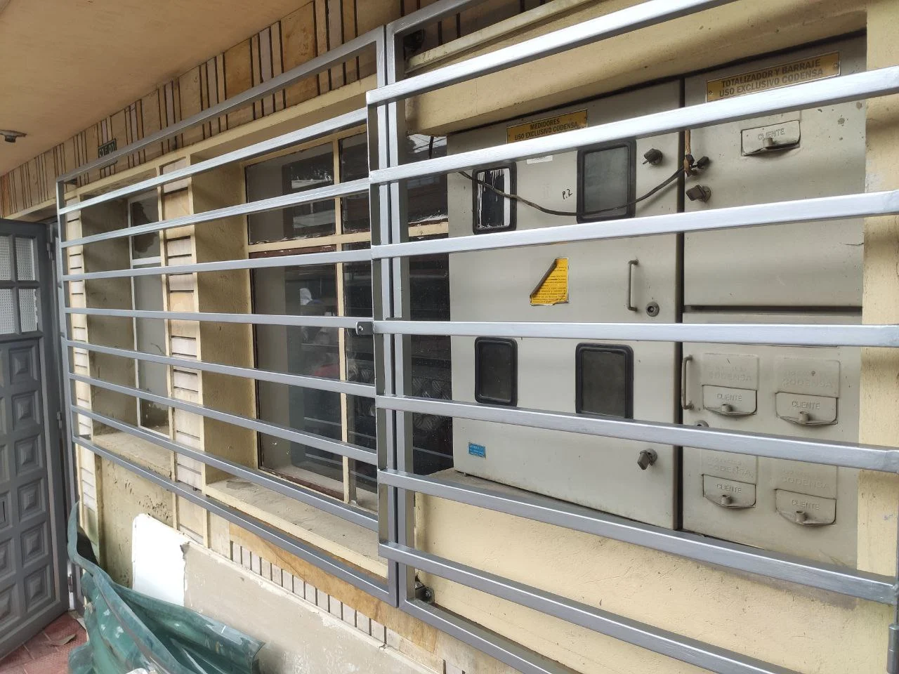 Reja metálica blanca protegiendo tableros eléctricos