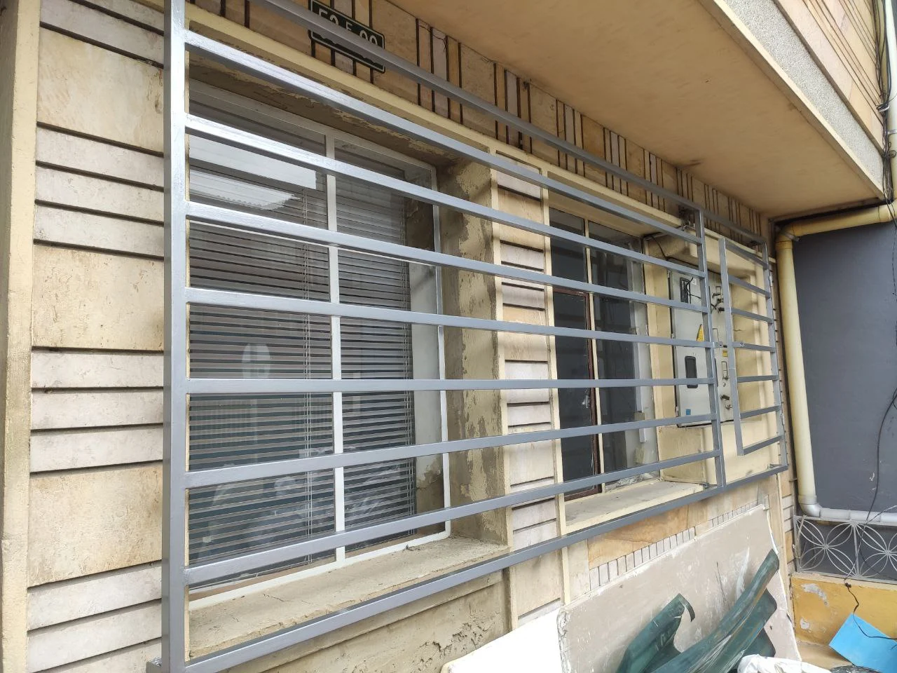 Reja metálica blanca de barrotes en ventana exterior