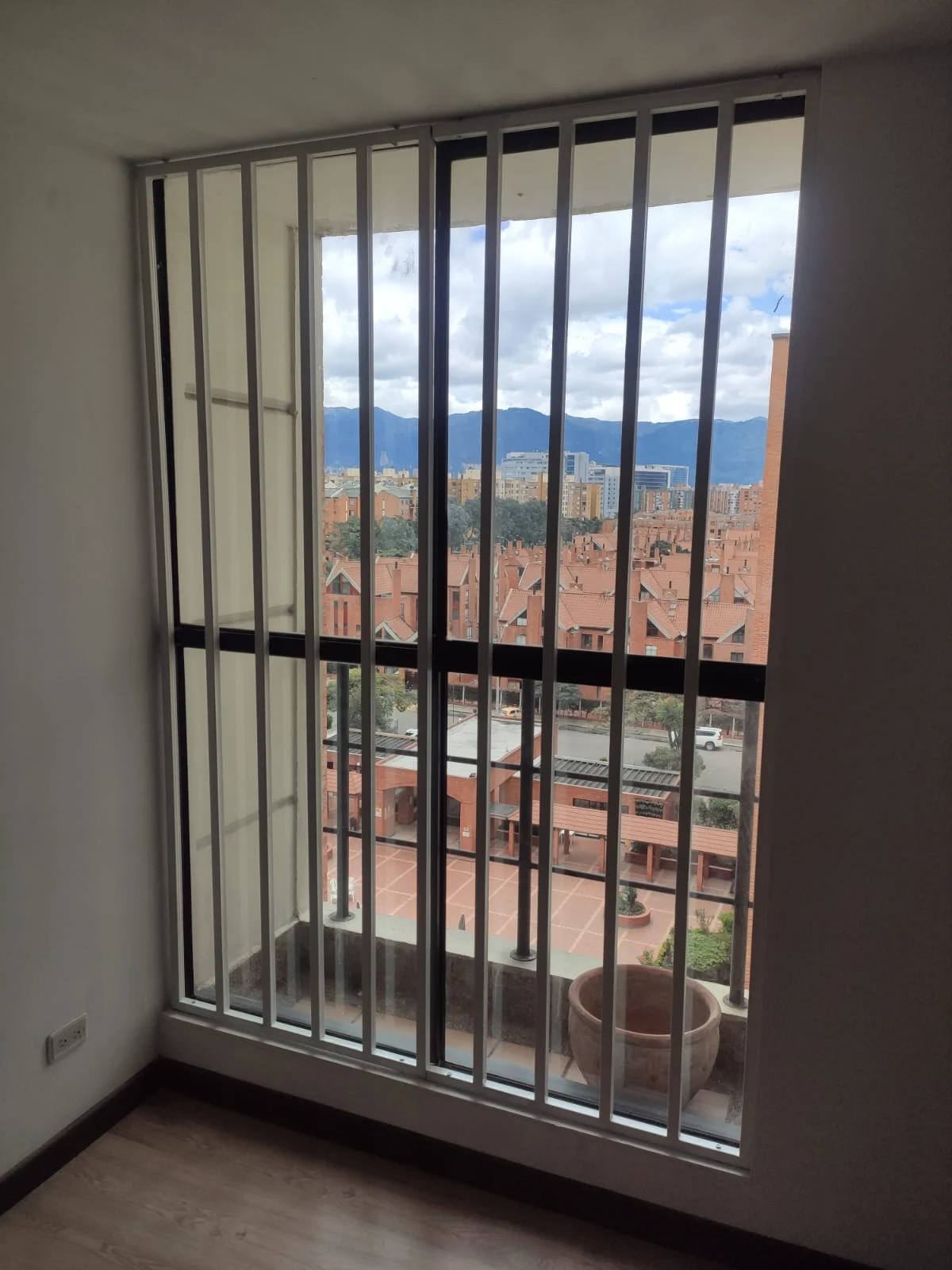 Reja metálica blanca de barrotes en ventana de apartamento
