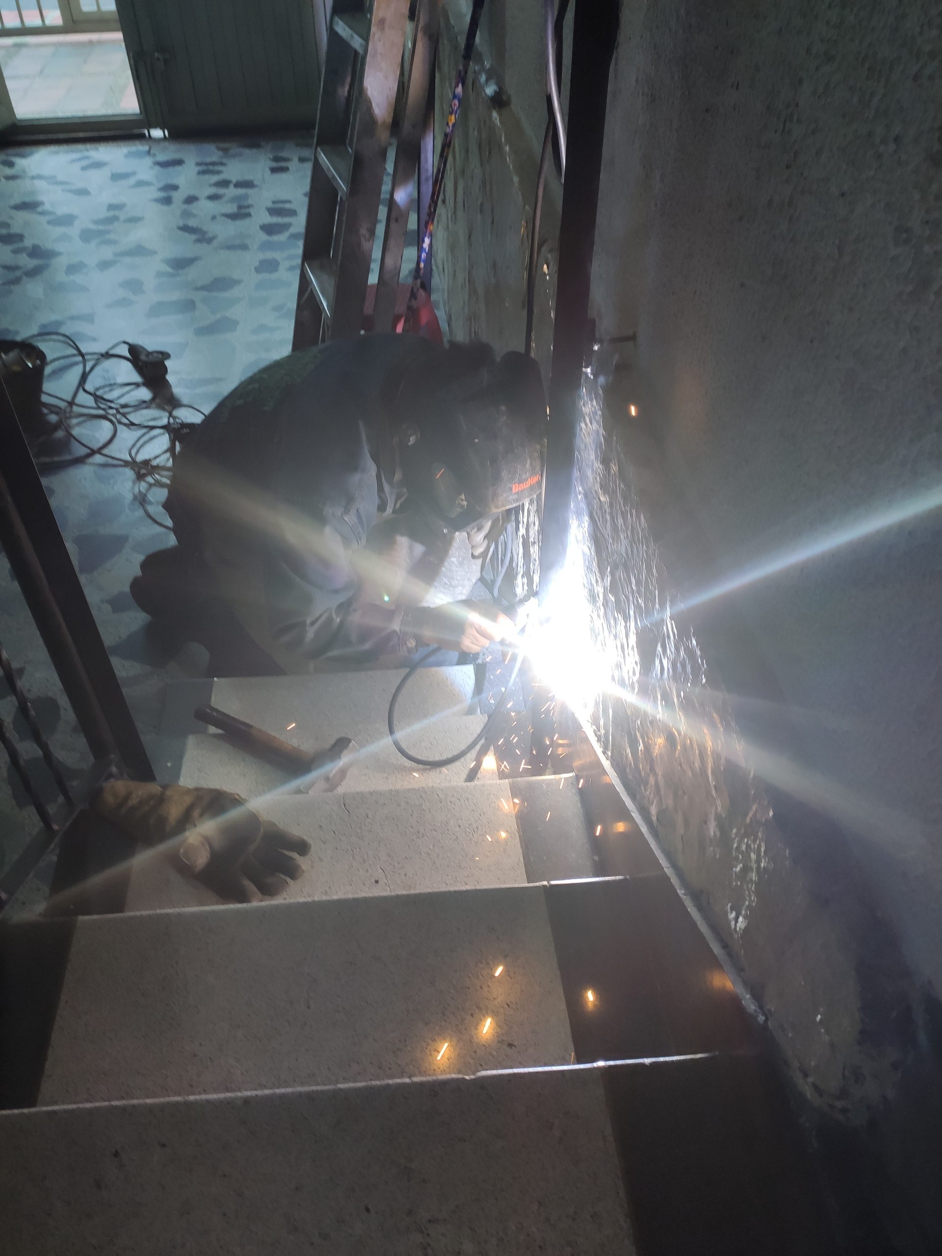 Soldador reparando ornamentación metálica en Bogotá - Comando Construcciones