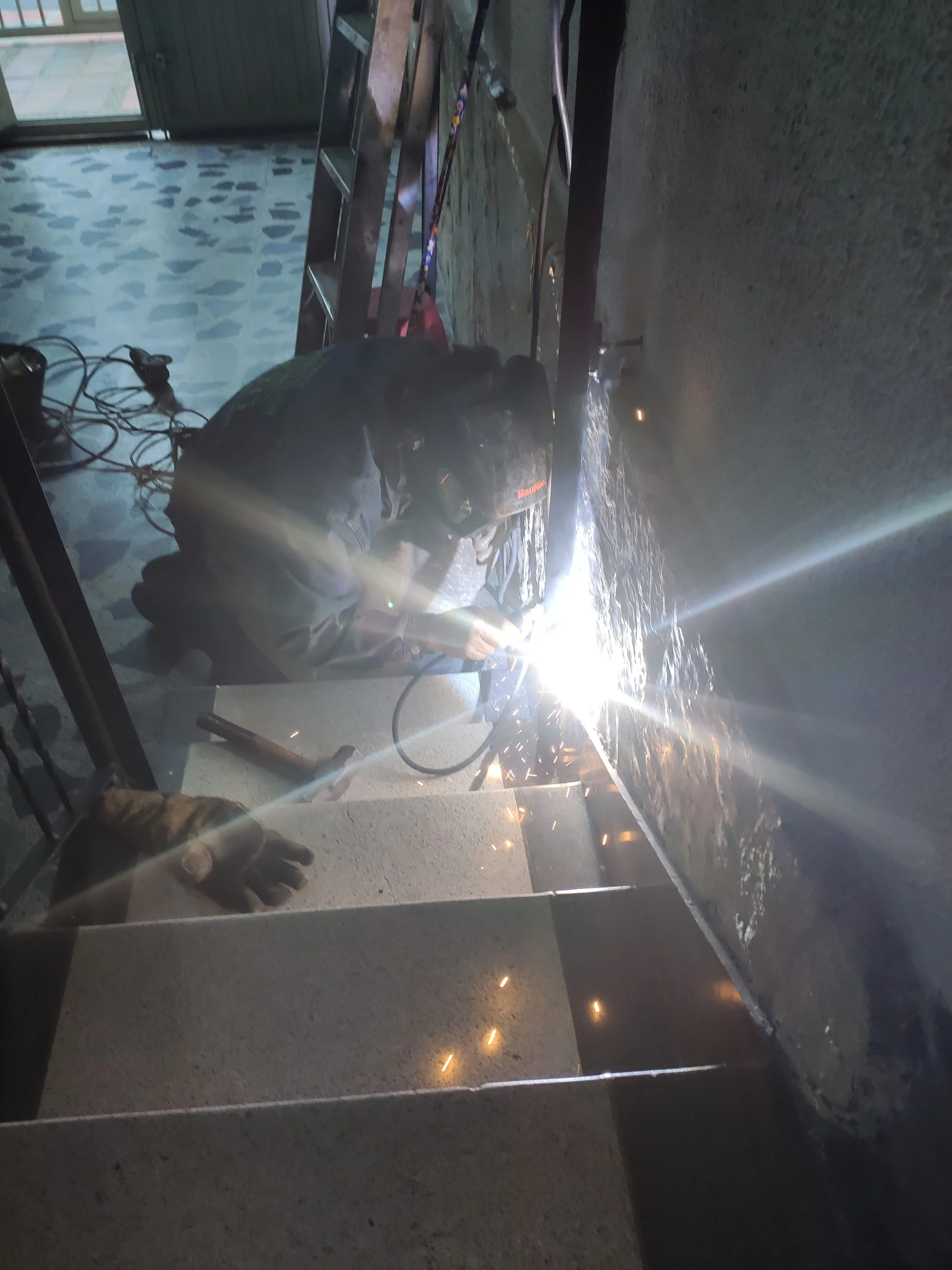 Soldador reparando ornamentación metálica en Bogotá - Comando Construcciones