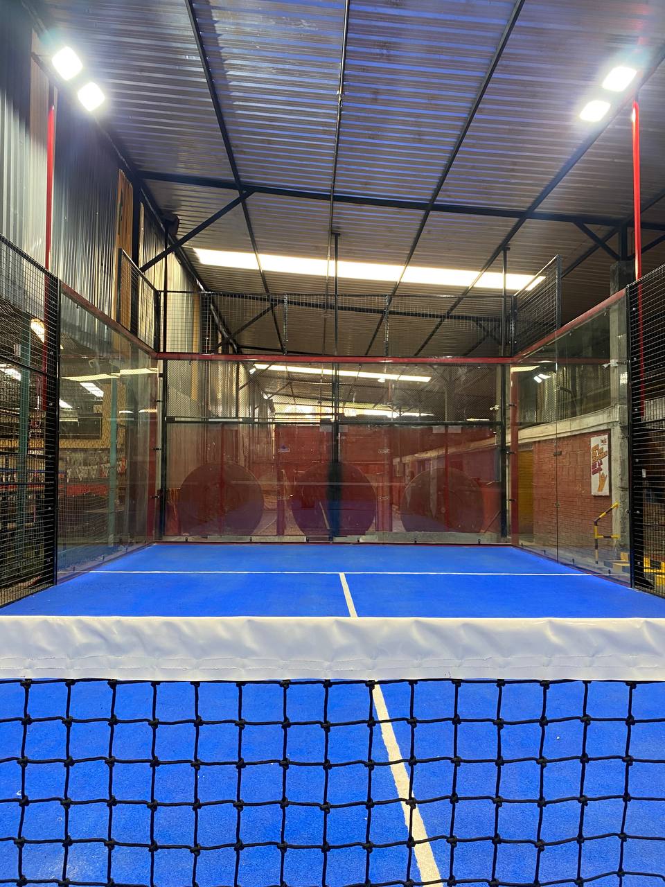 Canchas de pádel con piso azul y red en Bogotá