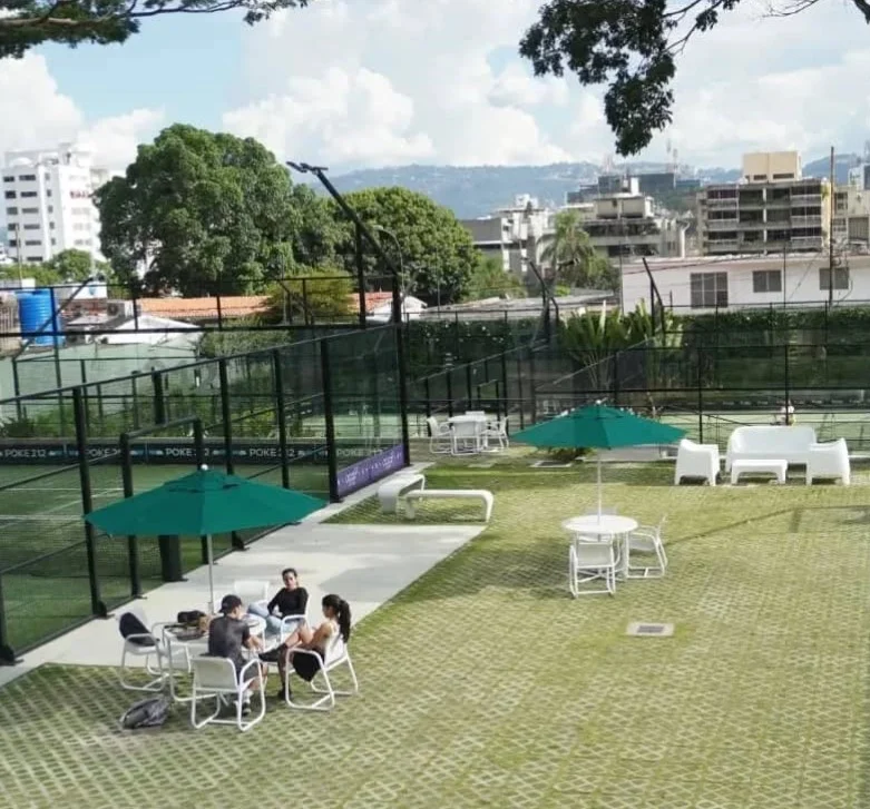 Canchas de pádel exteriores con estructuras de metal y áreas de descanso en un entorno urbano
