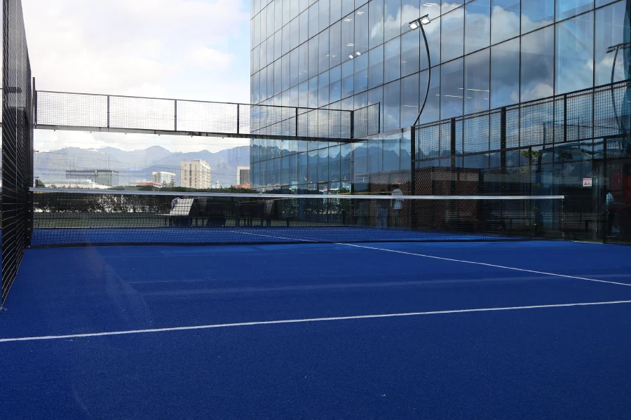 Canchas de pádel exteriores con superficie azul y cercas de metal en un centro comercial moderno