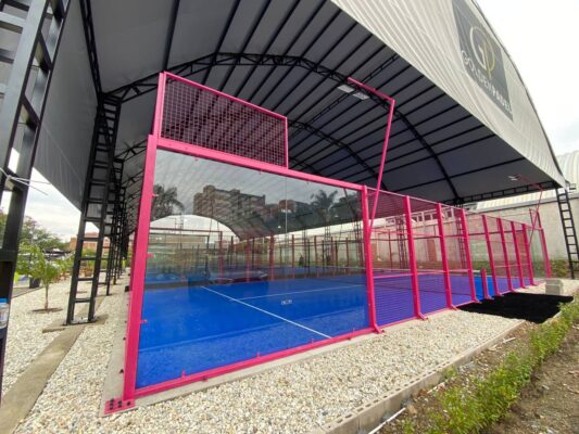 Canchas de pádel con estructura metálica y paneles de vidrio en Envigado, bajo techo y con cercas de metal rosa